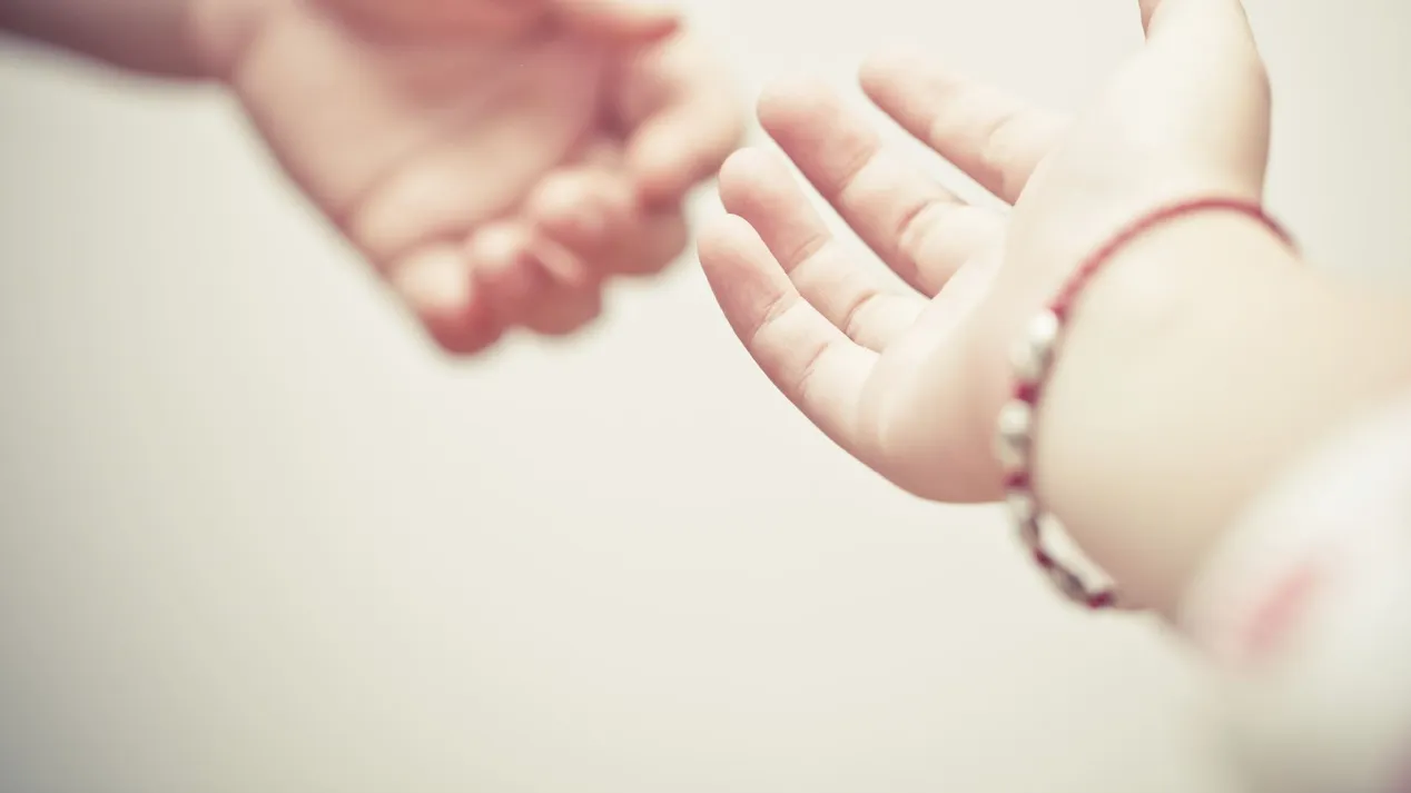 Hands trying to hold each other