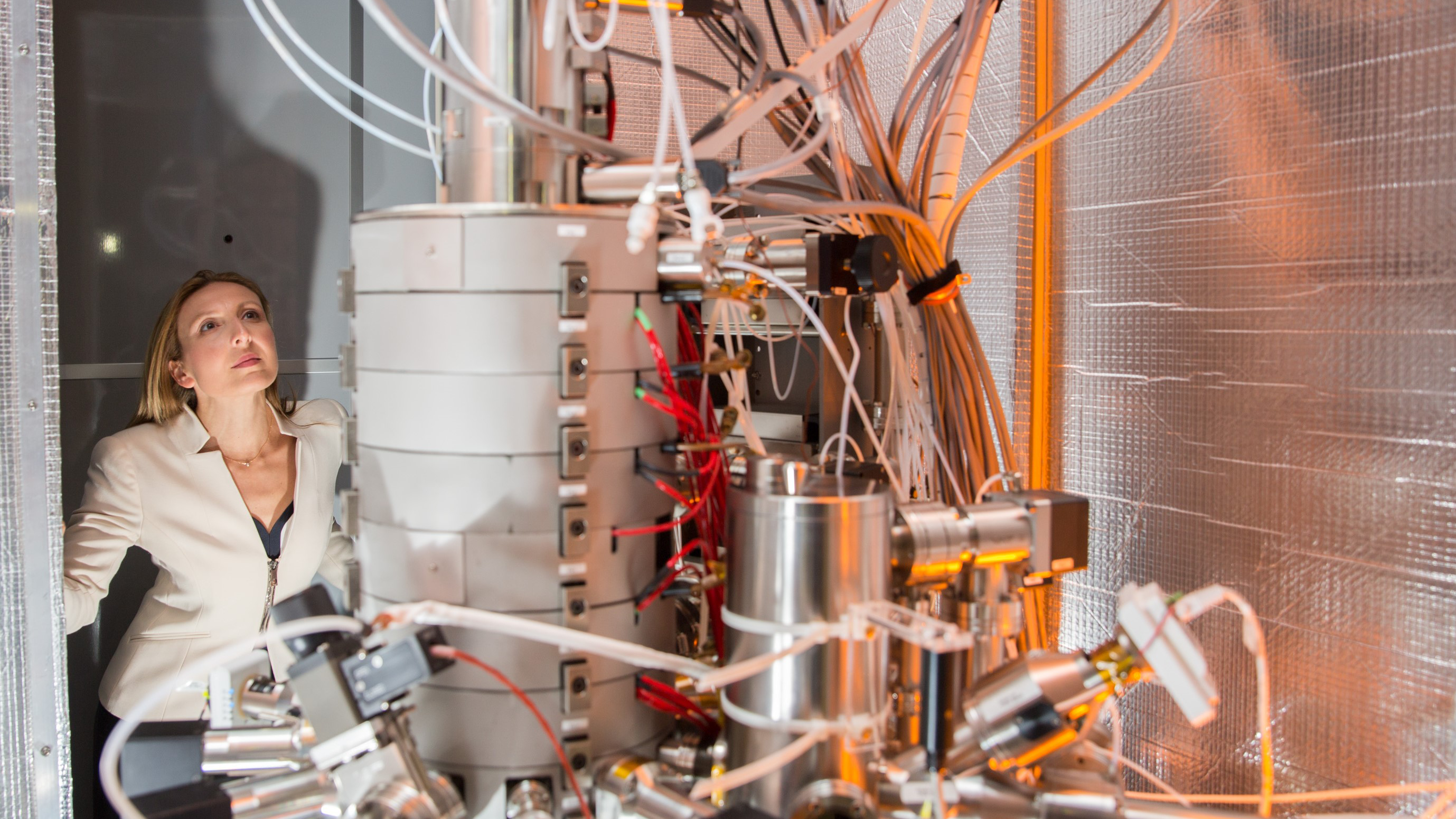 Professor Valeria Nicolosi with some of the lab equipment; a machine with many wires