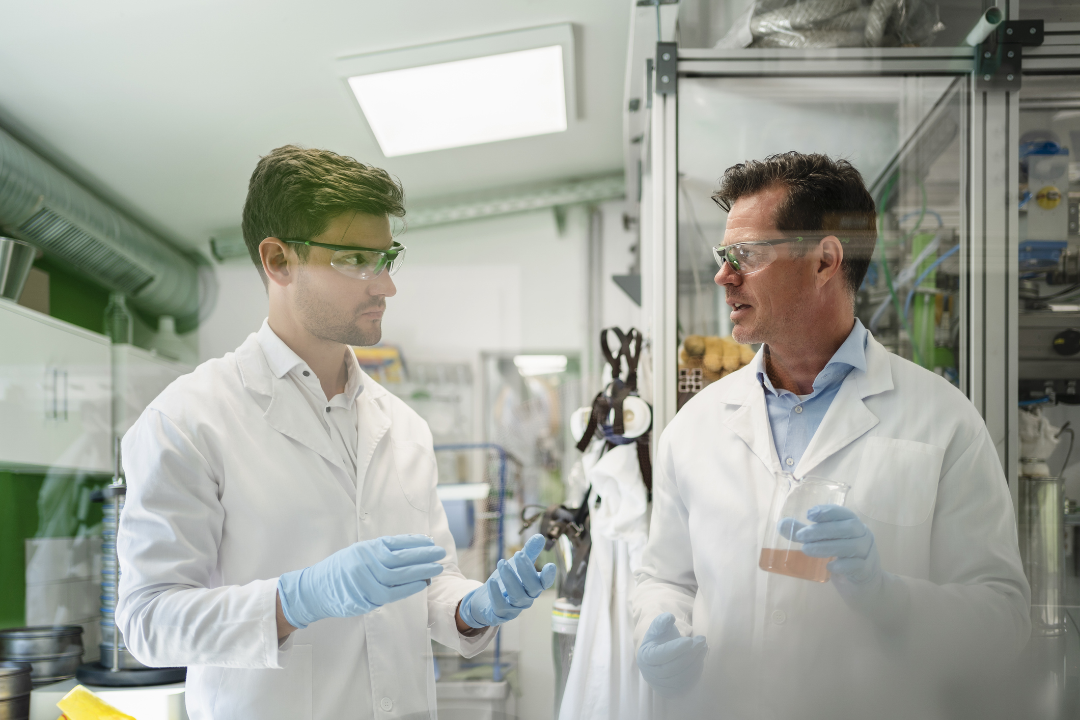 Scientists discussing with-colleague and doing thermolysis experiment in laboratory