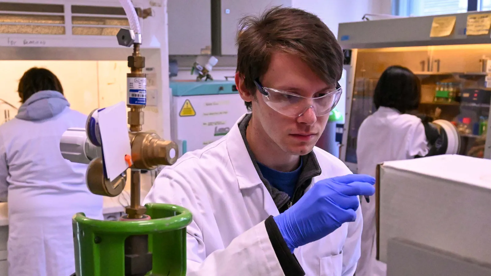 Biocatalytic Nitro Hydrogenations team member wearing goggles, gloves and lab coat, working in lab