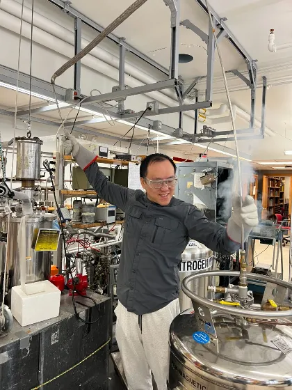 Nonheme iron-oxo oxidants team member wearing safety goggles and standing in a lab using equipment that is giving of white vapour