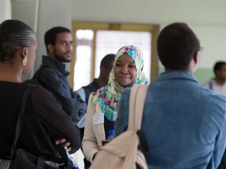 A Muslim woman standing with a group of people in an event