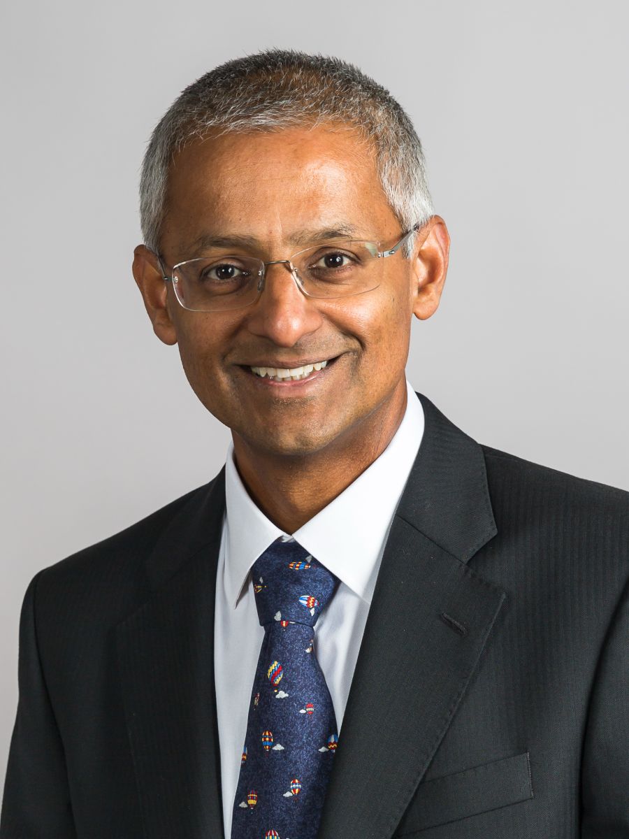 Sir Shankar Balasubramanian in a suit and tie smiling at camera