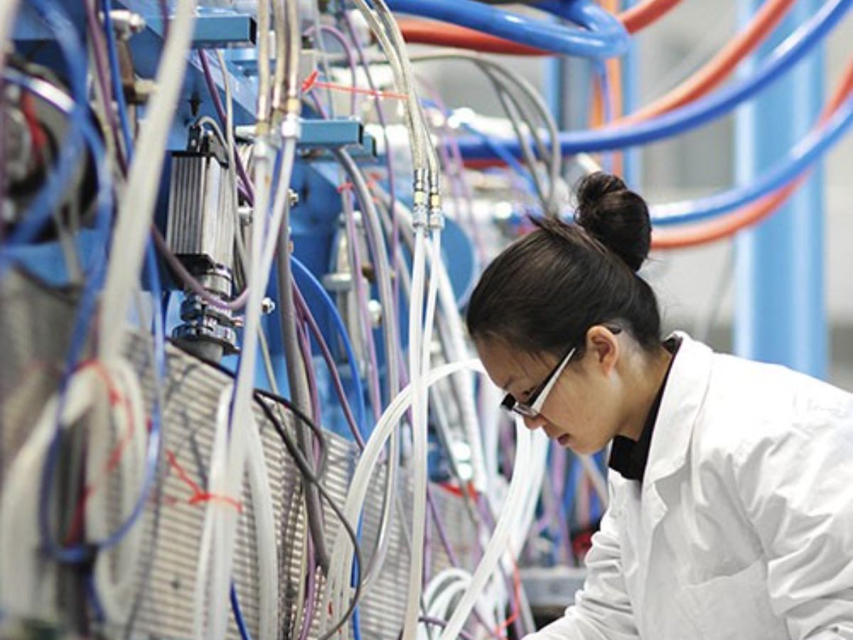 Young female in lab with web of pipes