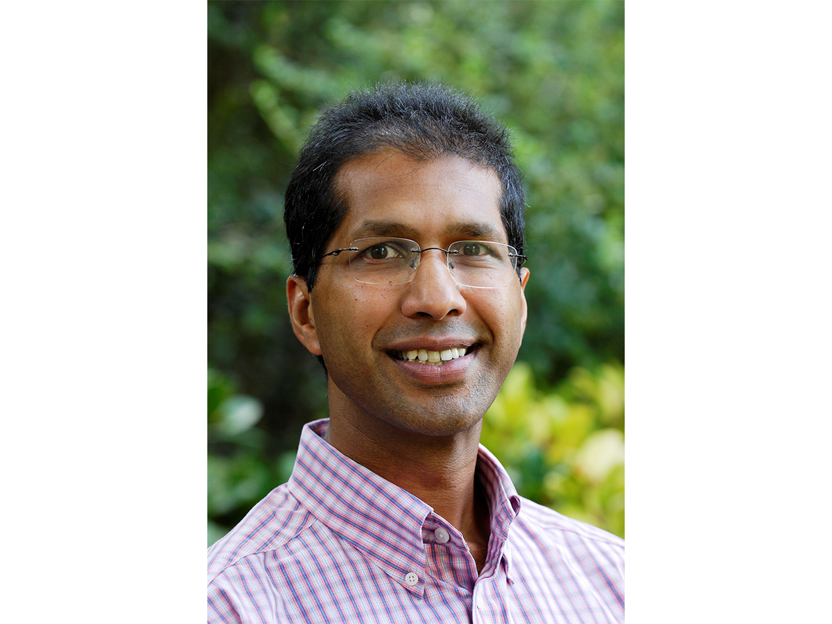 Professor Varinder Aggarwal wearing glasses and a pink and white checkered shirt