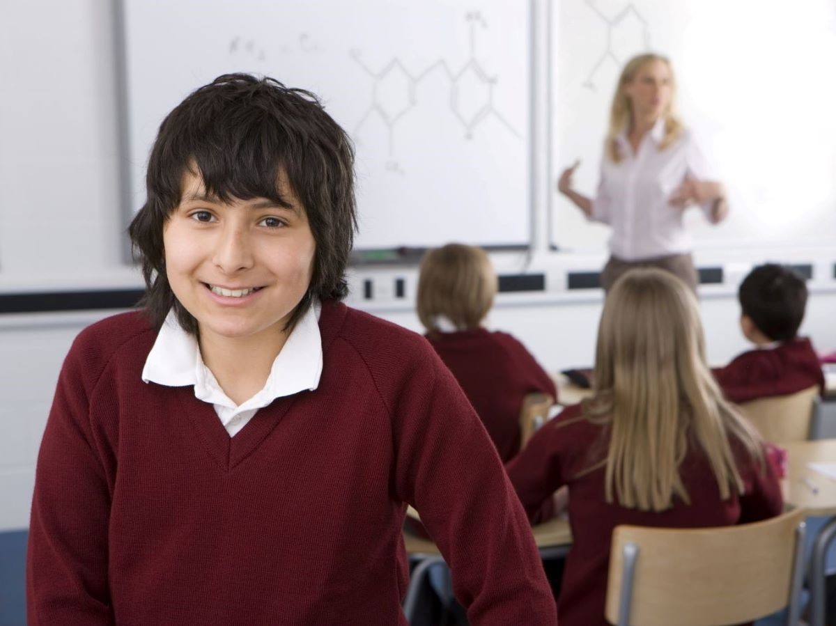 Young teenage boy in school uniform in classroom