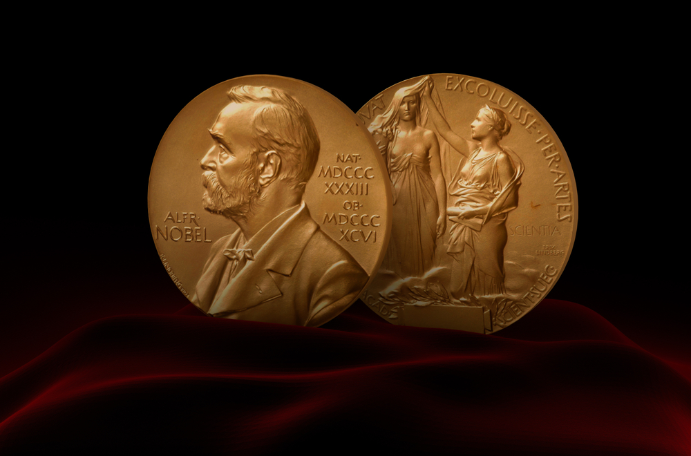 A Nobel Prize Medal standing on a platform set against a red and black background. A Nobel Prize Medal standing on a platform set against a red and black background.