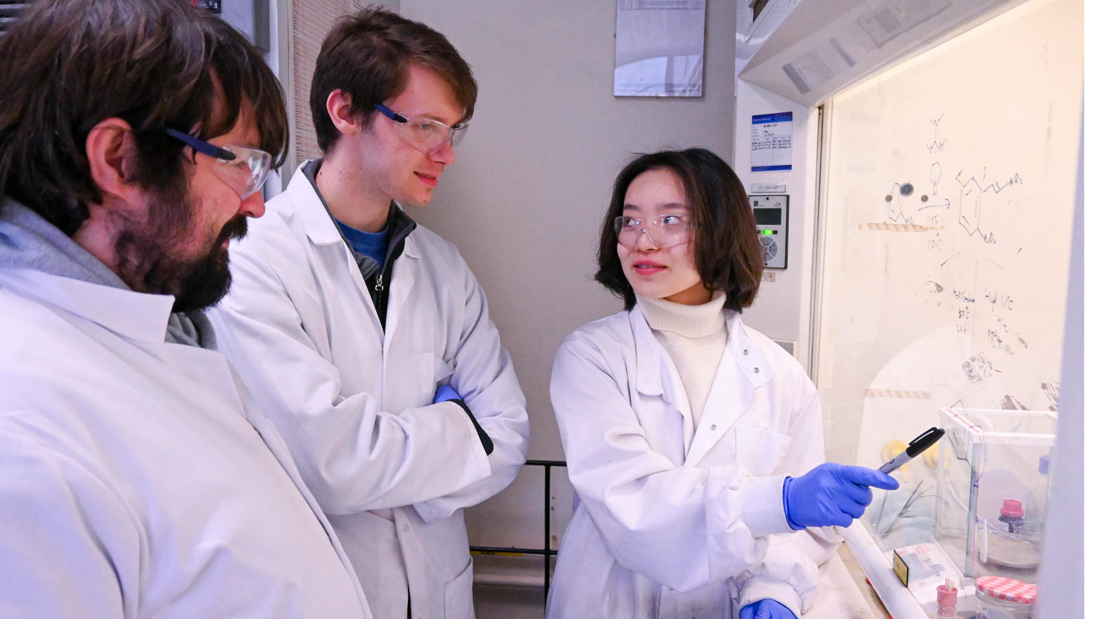 Three Biocatalytic Nitro Hydrogenations team members in white lab coats working in lab