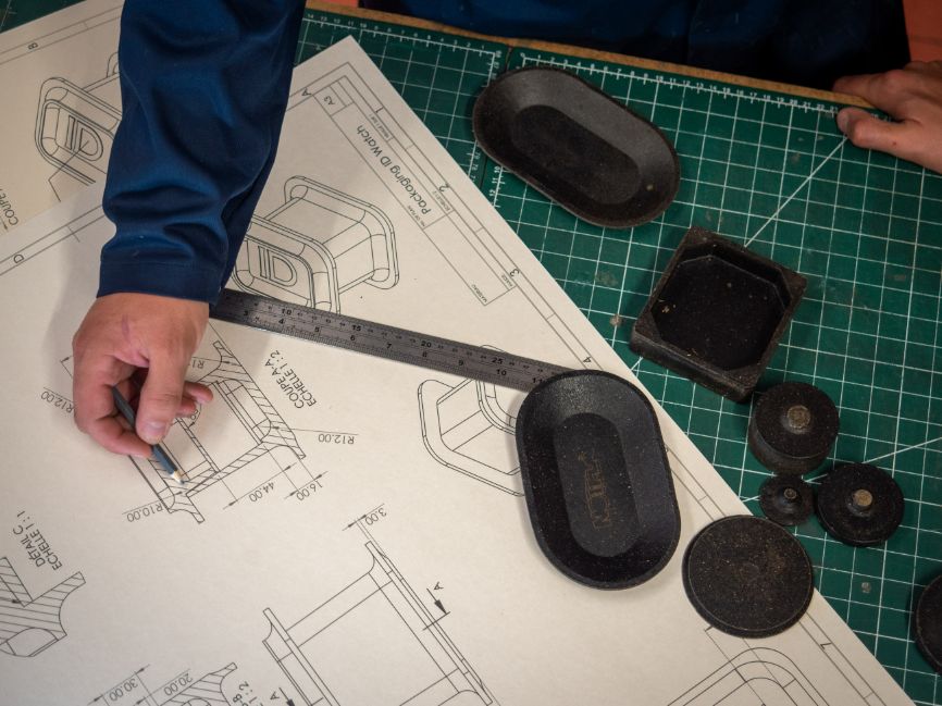 An arm holds a pencil over some schematics as work goes on to develop Notpla Rigid An arm holds a pencil over some schematics as work goes on to develop Notpla Rigid