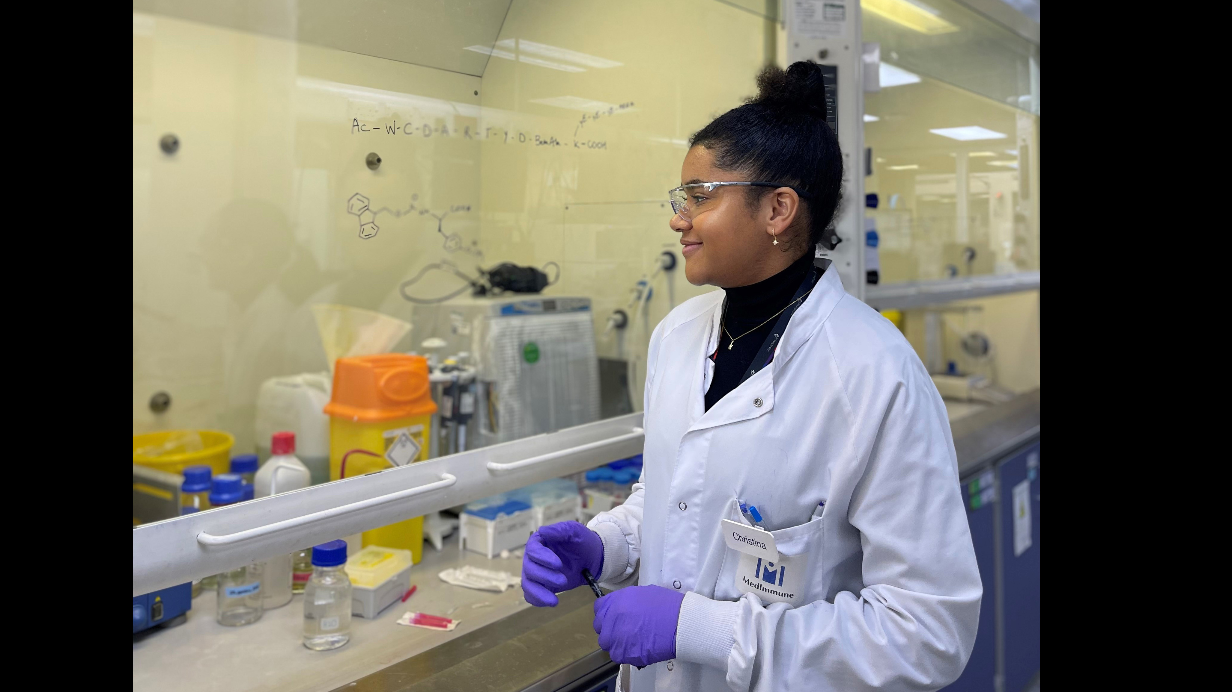 Christina Dumitriu Jackson wearing lab coat, goggles and gloves in a lab with equipment