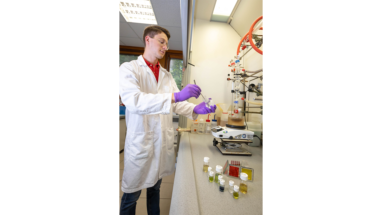 PISCO Team member in a lab coat and gloves with specimens in vials
