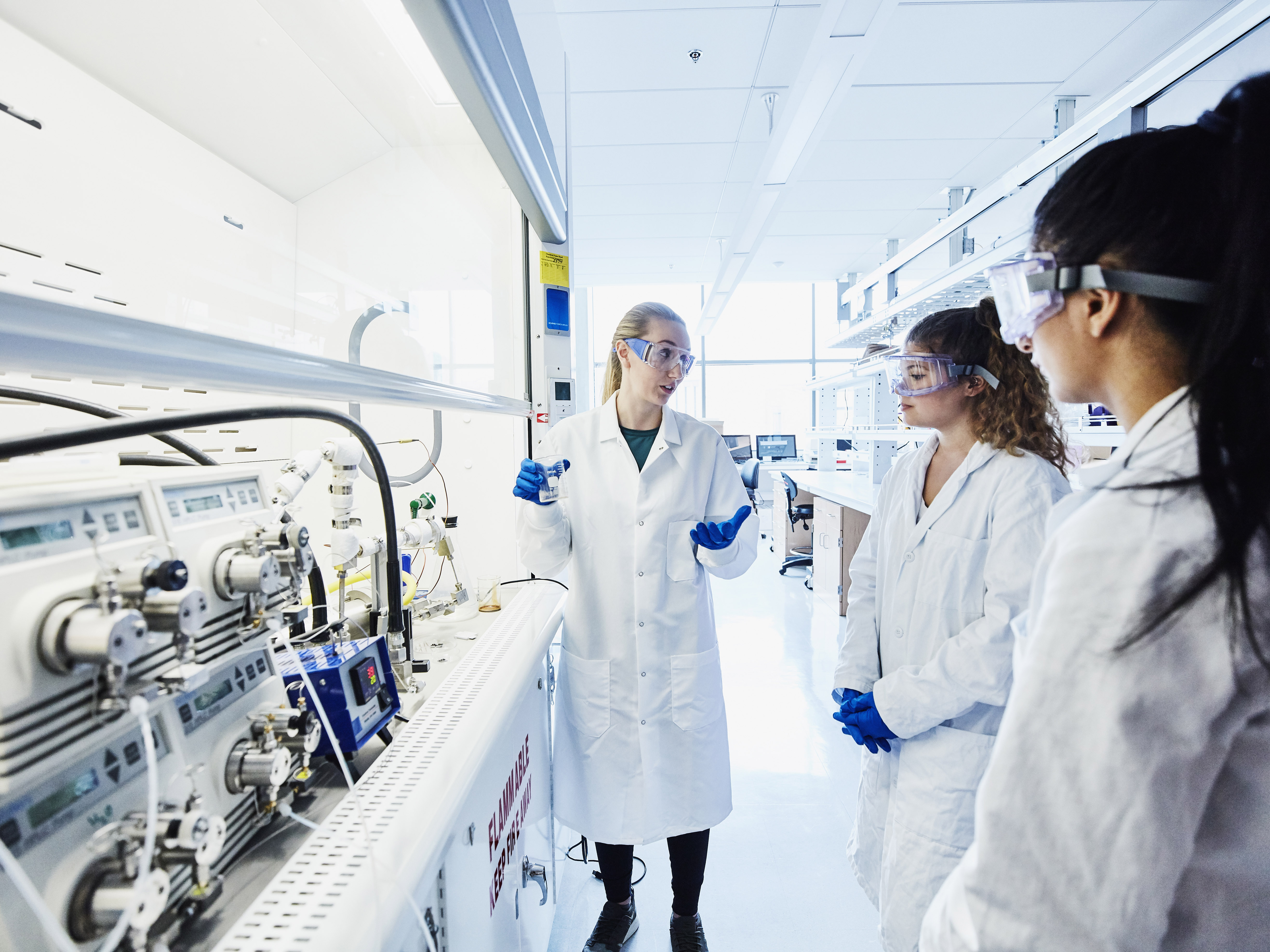 a group of people in white coats in a lab