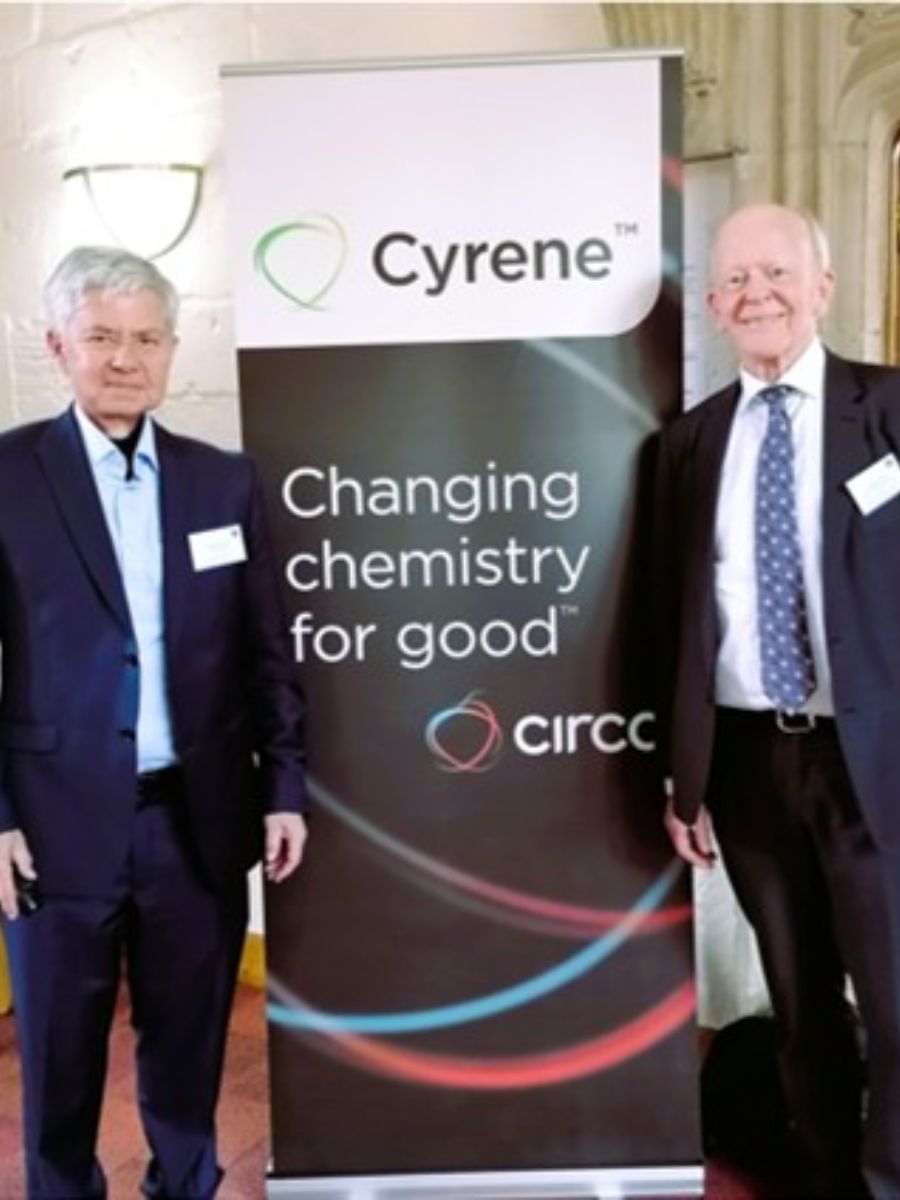 Two of Green Circular Solvent Team standing in front of a sign with text "Changing chemistry for good"