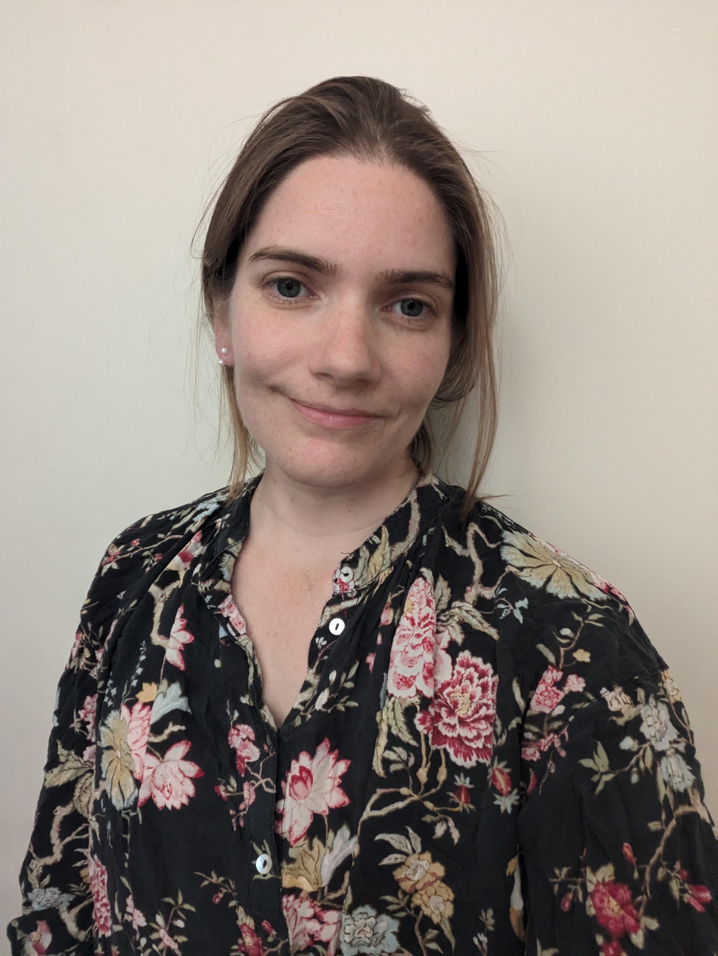 A portrait photo of a smiling Izzi Monk against a white background A portrait photo of a smiling Izzi Monk against a white background