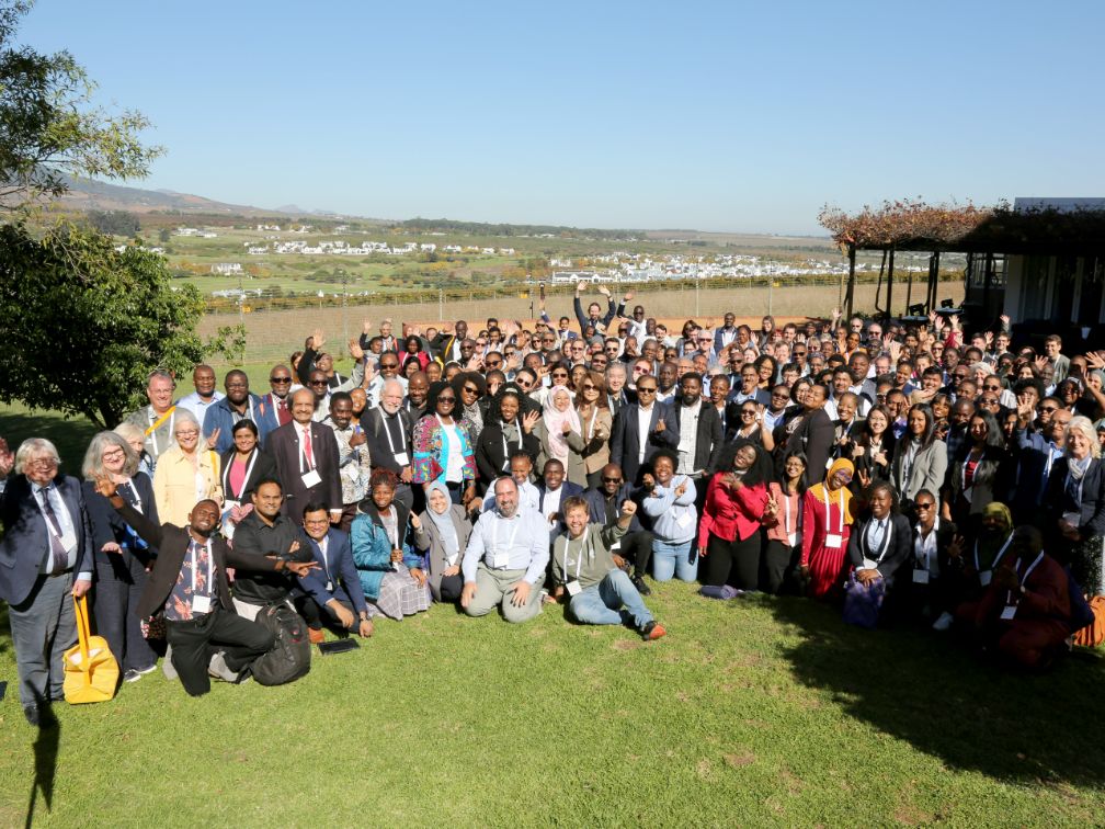 Group posing outside for photo with rural backdrop
