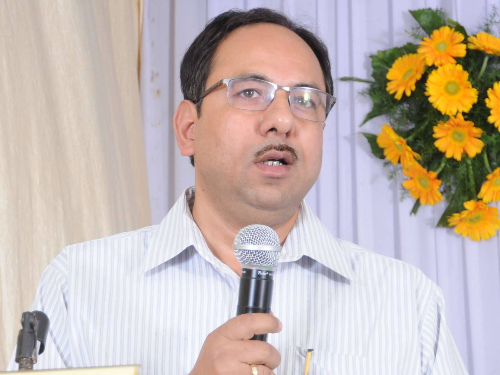 Head and shoulders shot of Professor Manojit Pal holding a microphone. Head and shoulders shot of Professor Manojit Pal holding a microphone.
