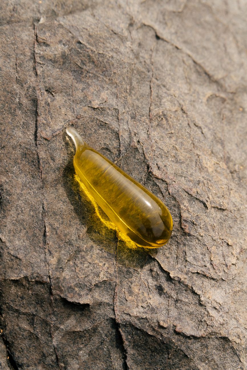 A Notpla Pipette filled with oil against a rocky backdrop
