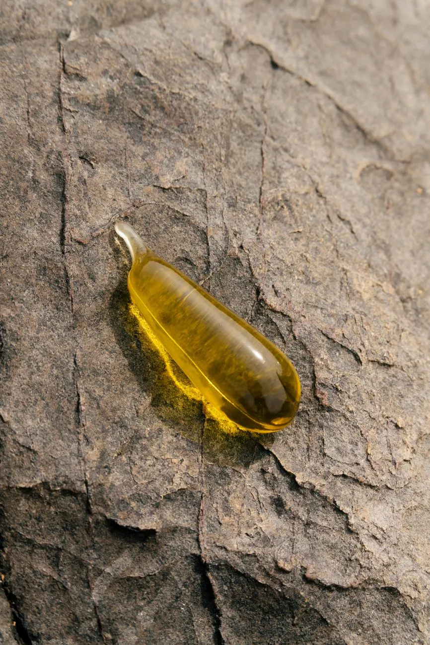 A Notpla Pipette filled with oil against a rocky backdrop