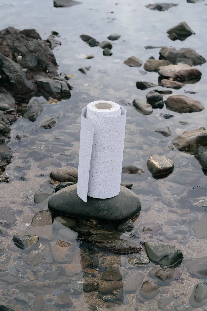 A roll of Notpla Paper stood on a stone