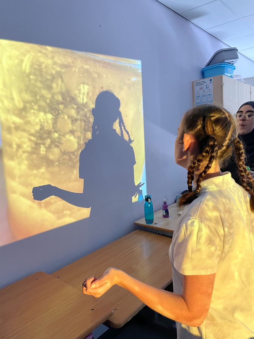 A girl looks at an image projected onto a wall A girl looks at an image projected onto a wall