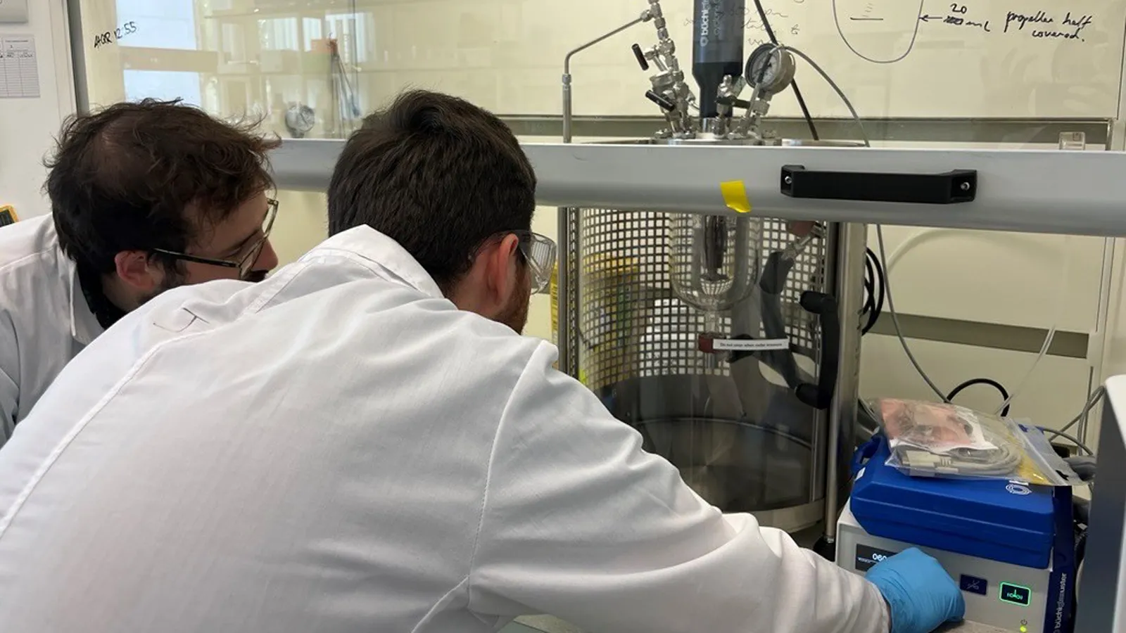 Two males from the team in lab coats in a lab