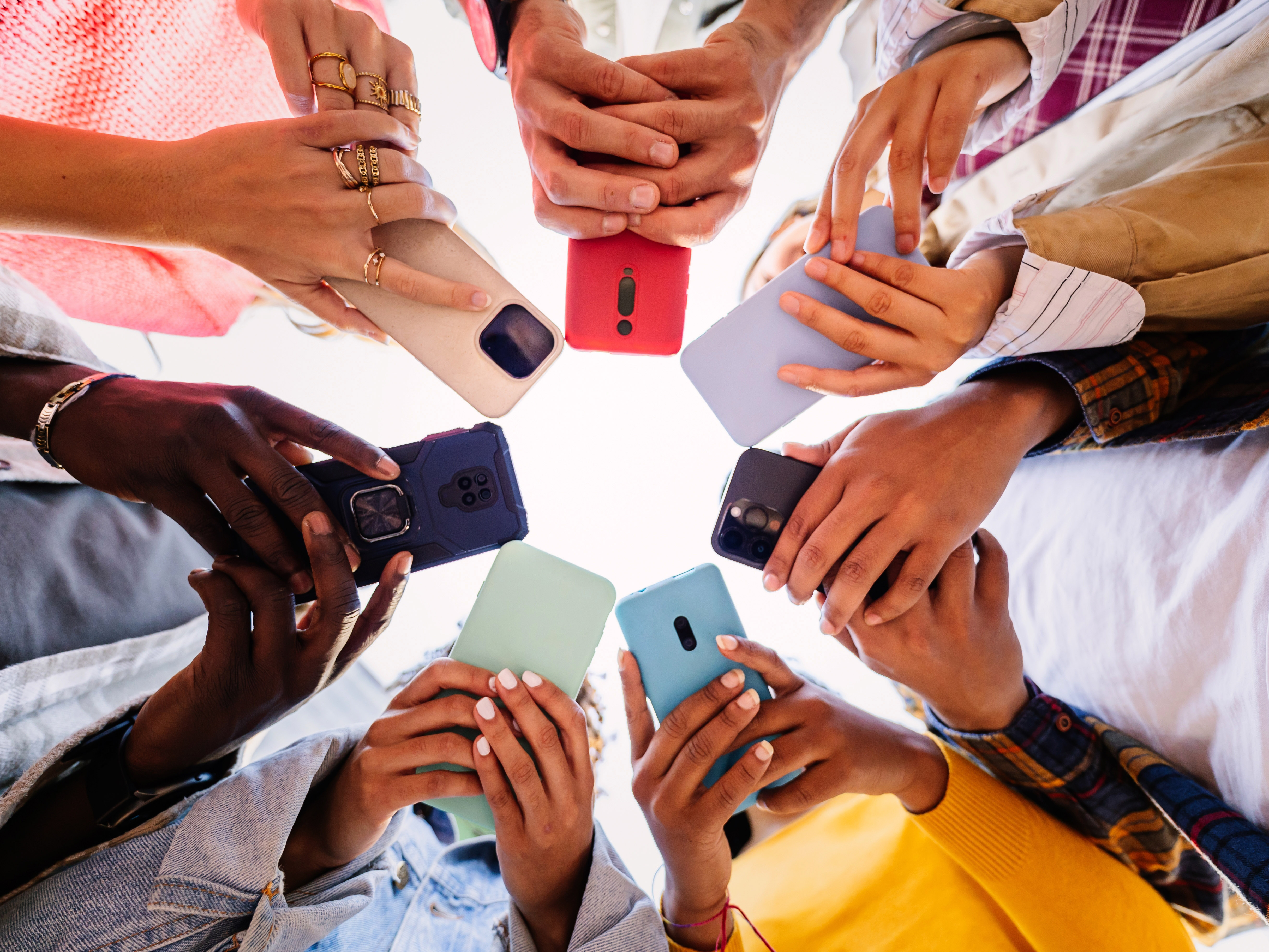 group of people holding their phones in a circle