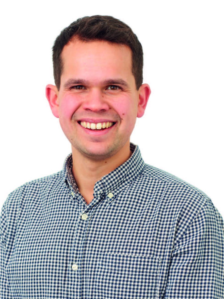 Dr Emrys Evans smiling at the camera in a check shirt