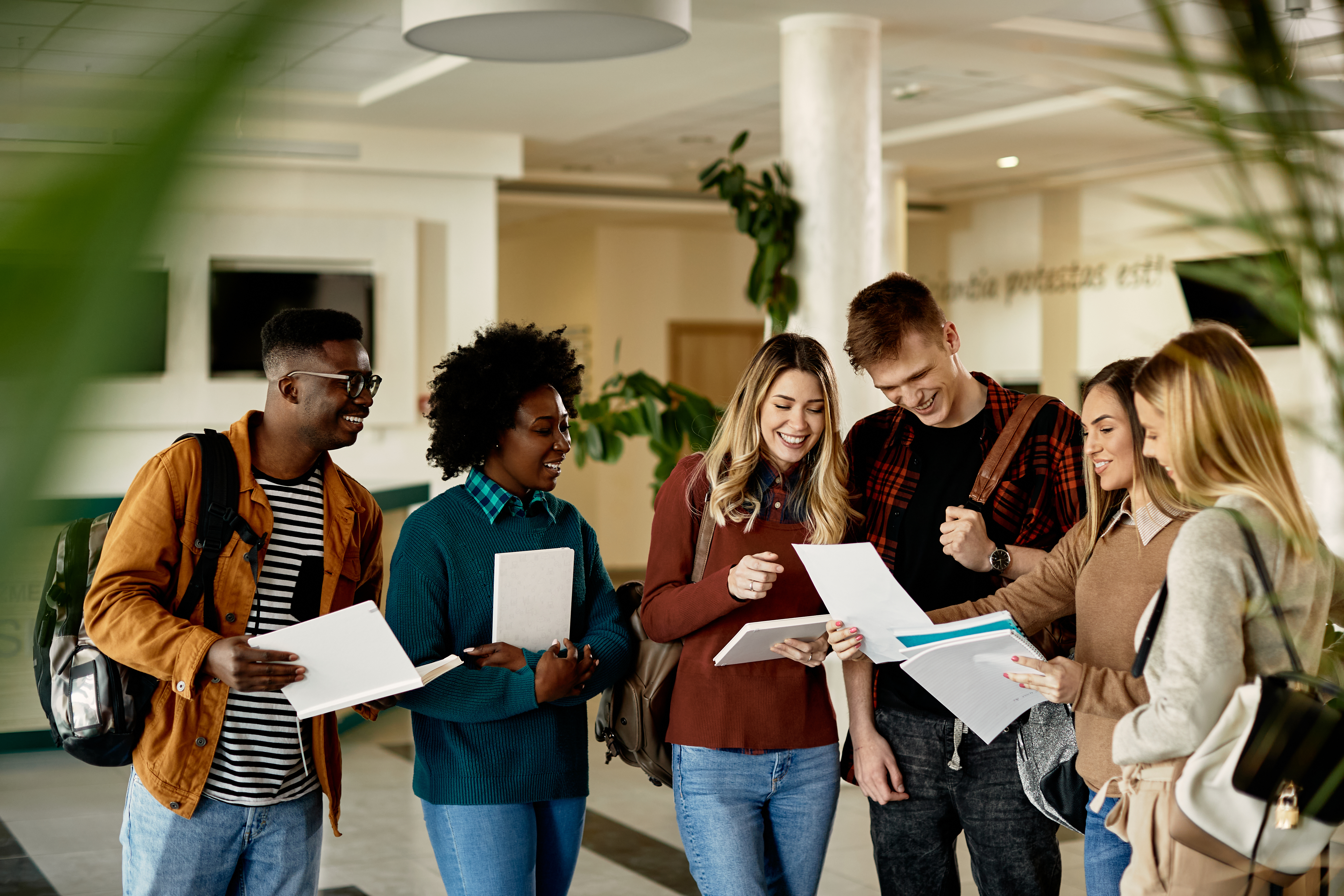 A group of six young people stand around celebrating their exam results