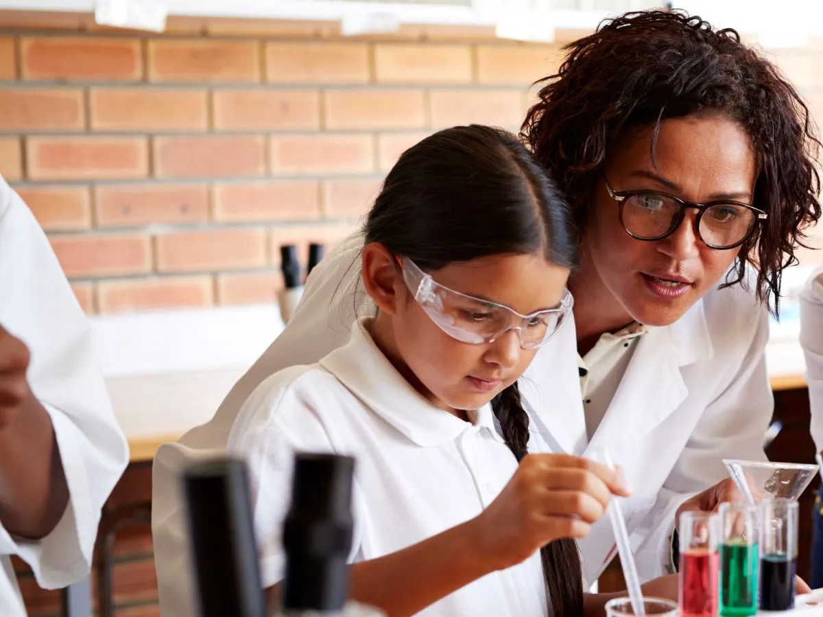 Female teacher with female pupil in science lab