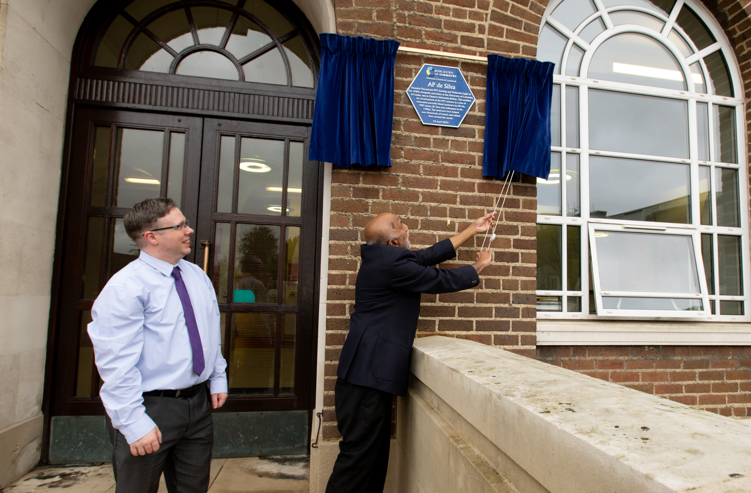 Professor AP de Silva unveils the National Chemical Landmark plaque in his honour at Queen's University Belfast, while Dr Kevin Morgan watches on Professor AP de Silva unveils the National Chemical Landmark plaque in his honour at Queen's University Belfast, while Dr Kevin Morgan watches on