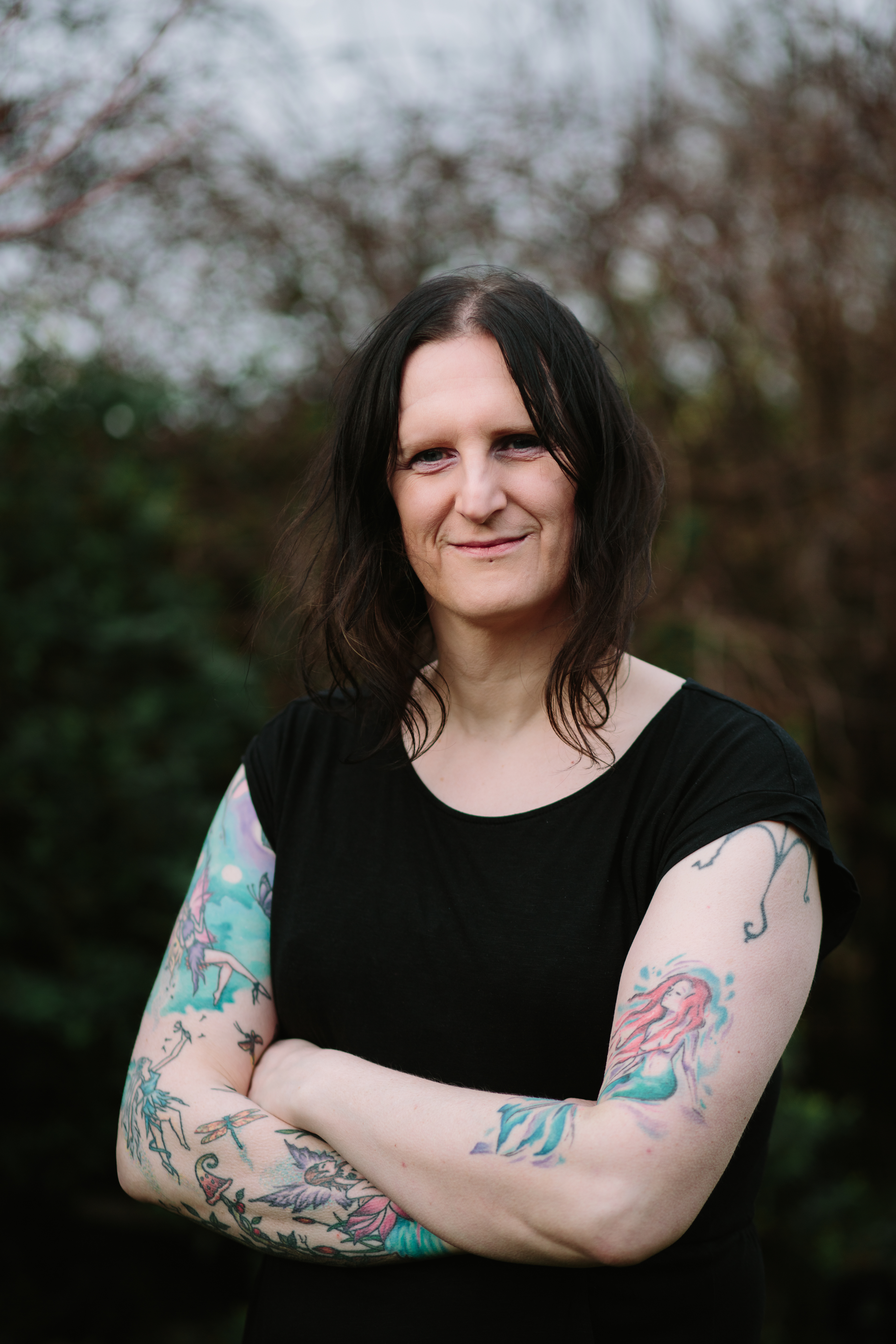 Dr Clara Barker standing smiling with her arms folded