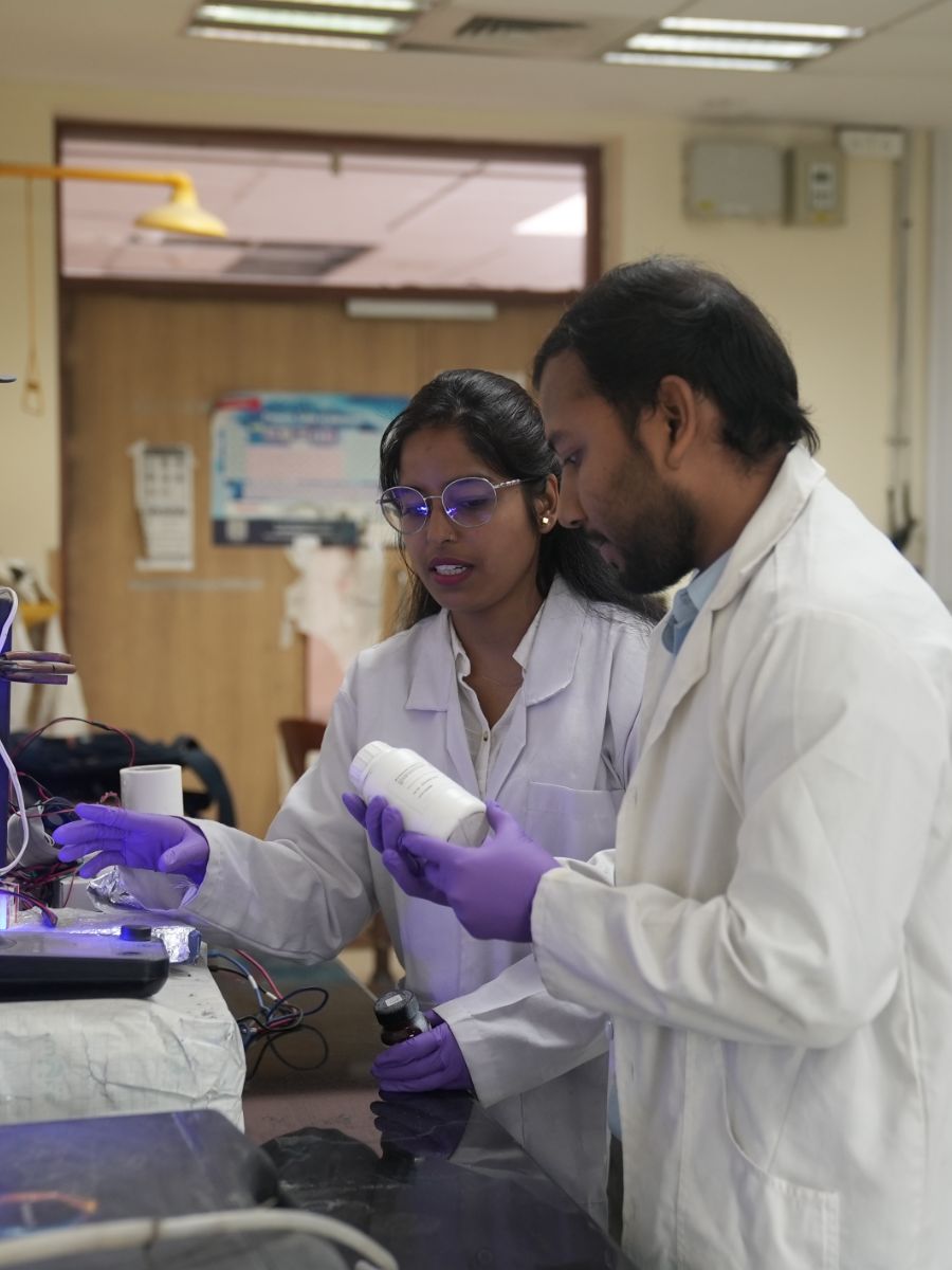 AEEon Collective team members in lab coats and gloves working with their equipment