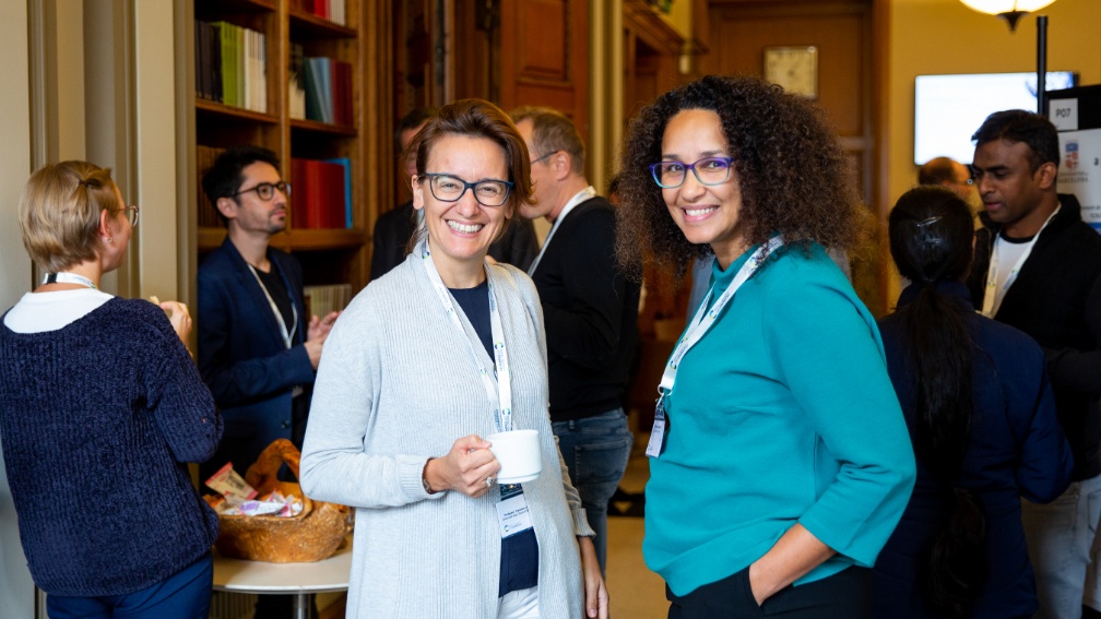 Two people standing and smiling towards camera