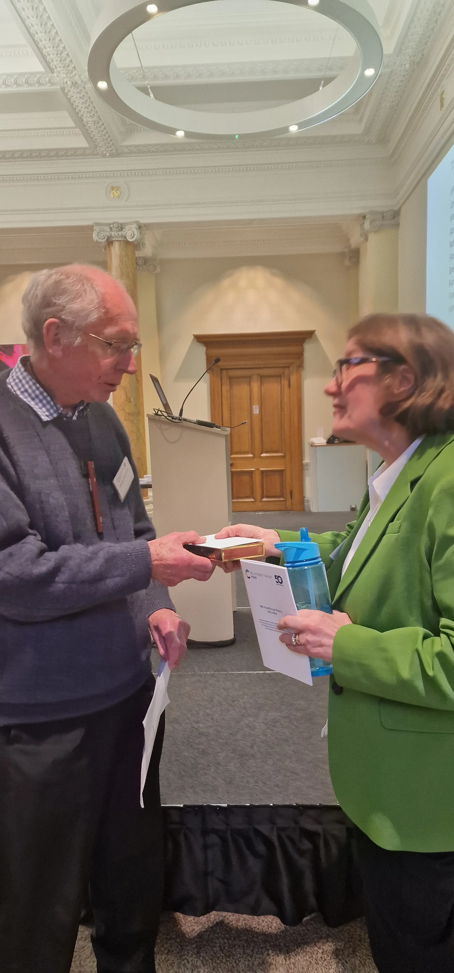 Former Food Group Chair Mike Saltmarsh and current Chair Professor Jane K Parker stand and talk at the 50th anniversary celebration