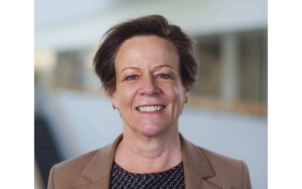 Professor Donna Blackmond in brown suit jacket smiling at camera