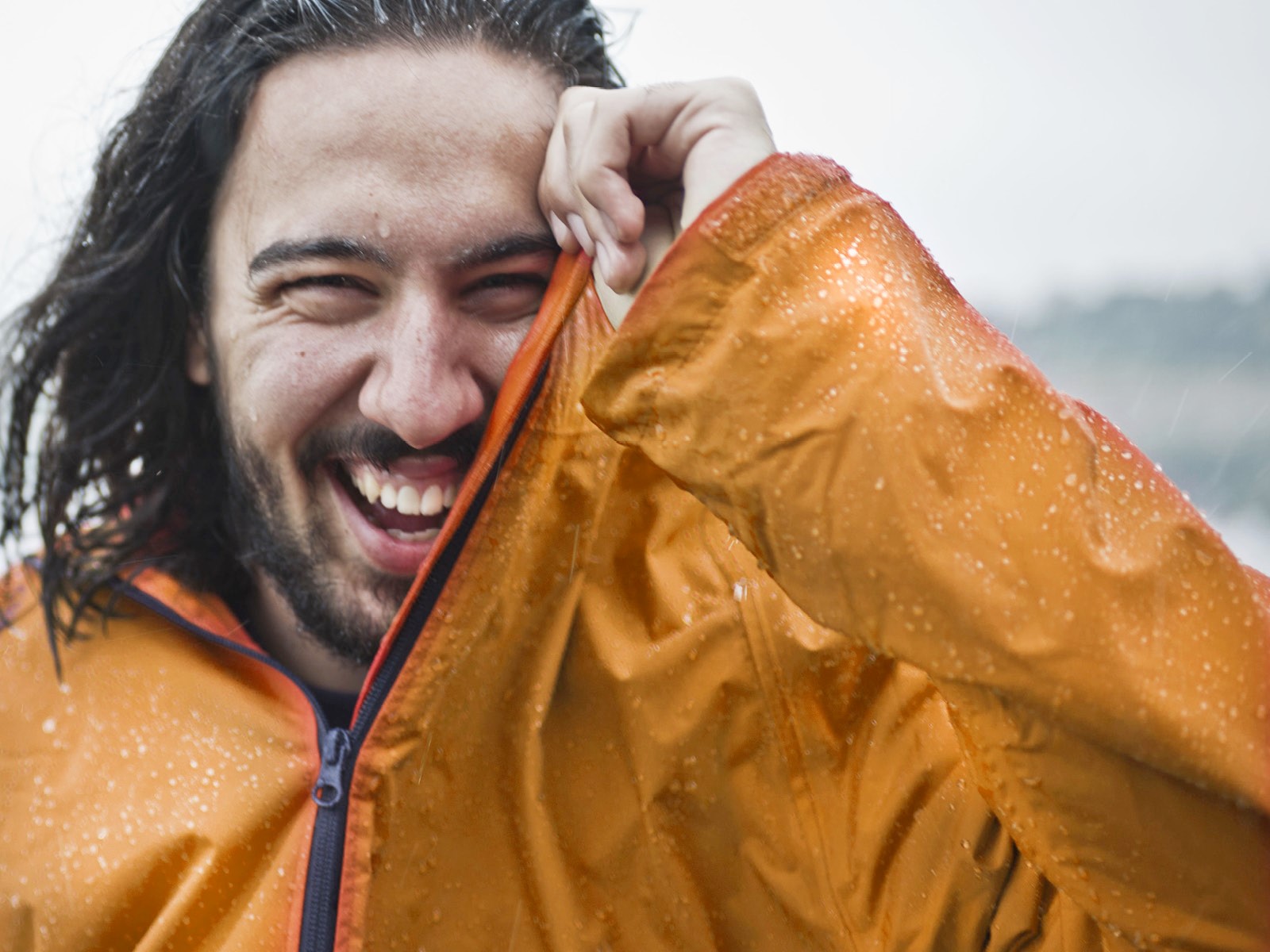 A man is pictured in an orange waterproof raincoat