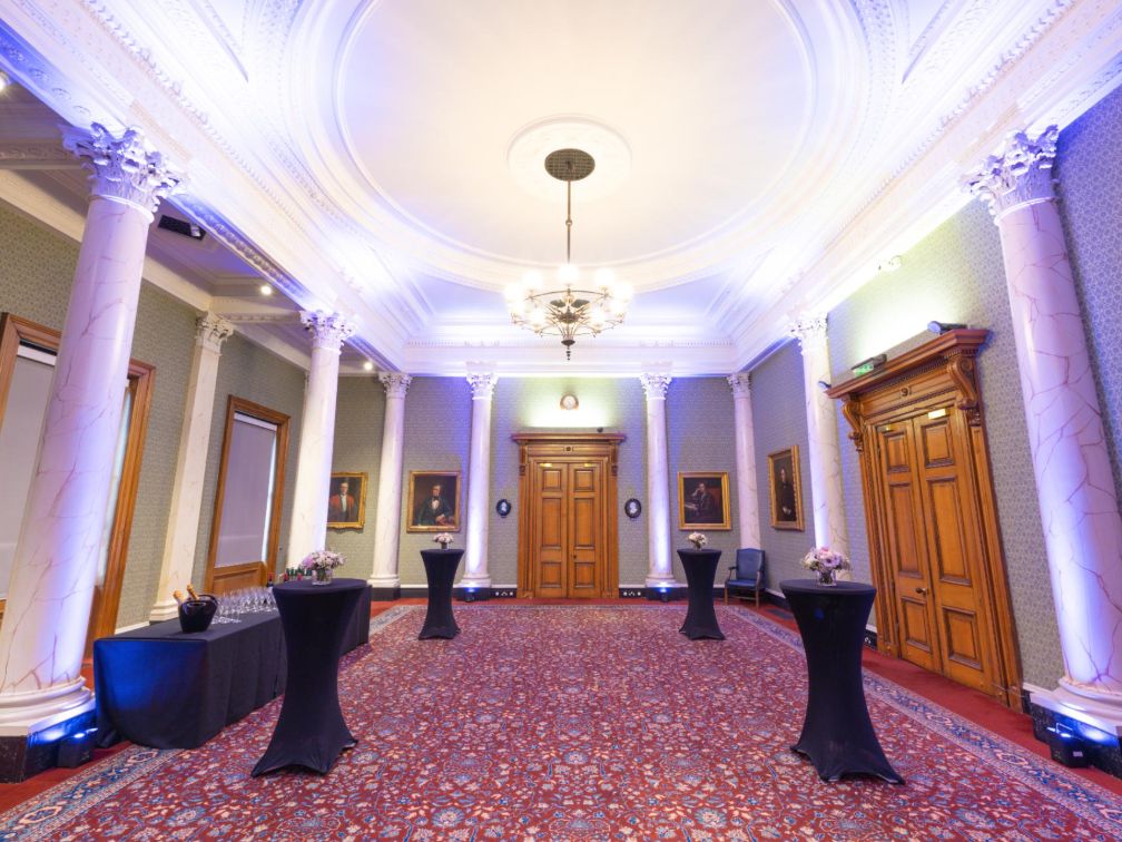 Council room with purple lighting and drinks reception at Burlington House