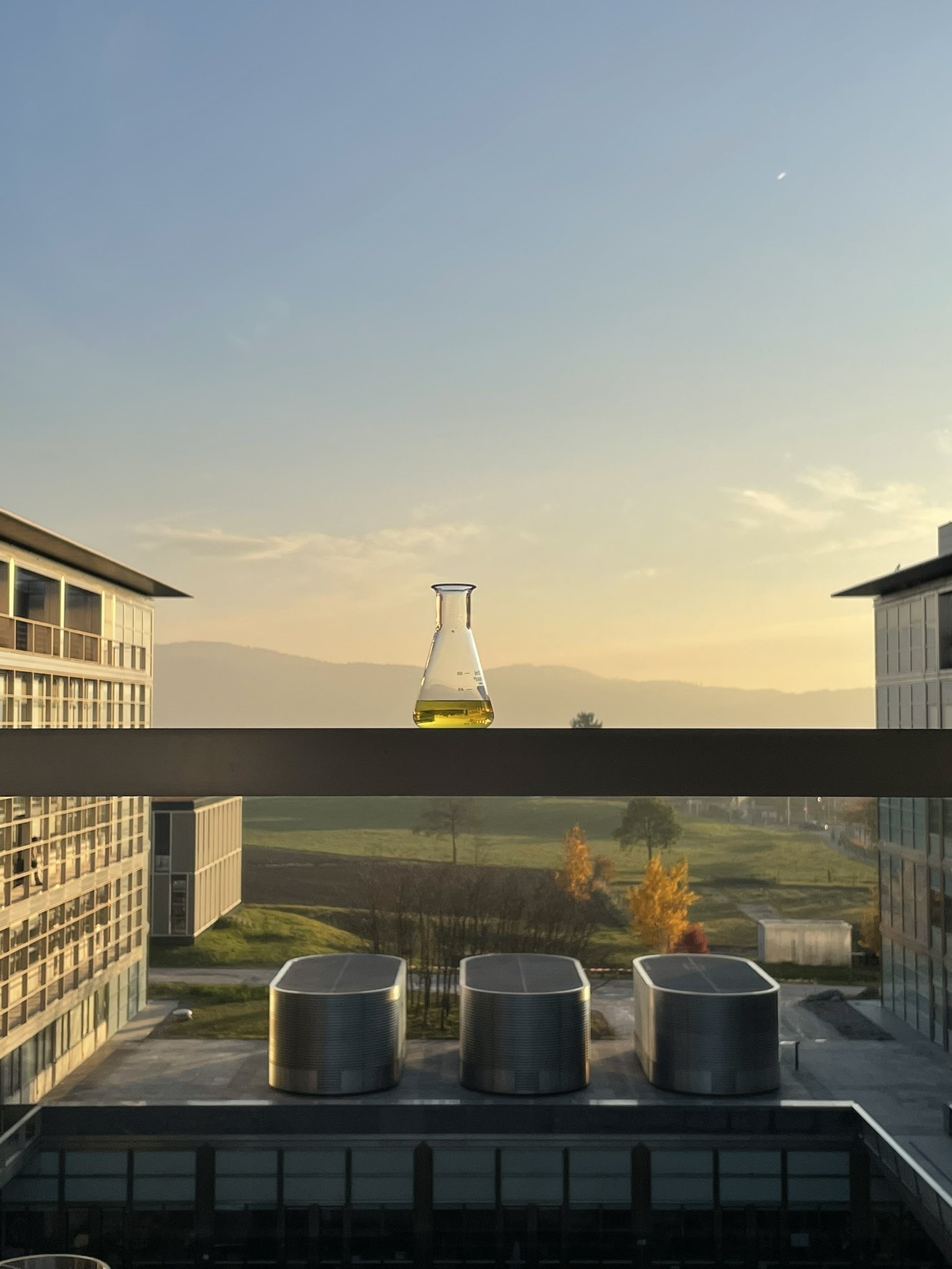 Marie Perrin's 'Chemistry is Everywhere' shows a beaker of liquid balanced on a window sill in front of a beautiful countryside scene at the end of the day