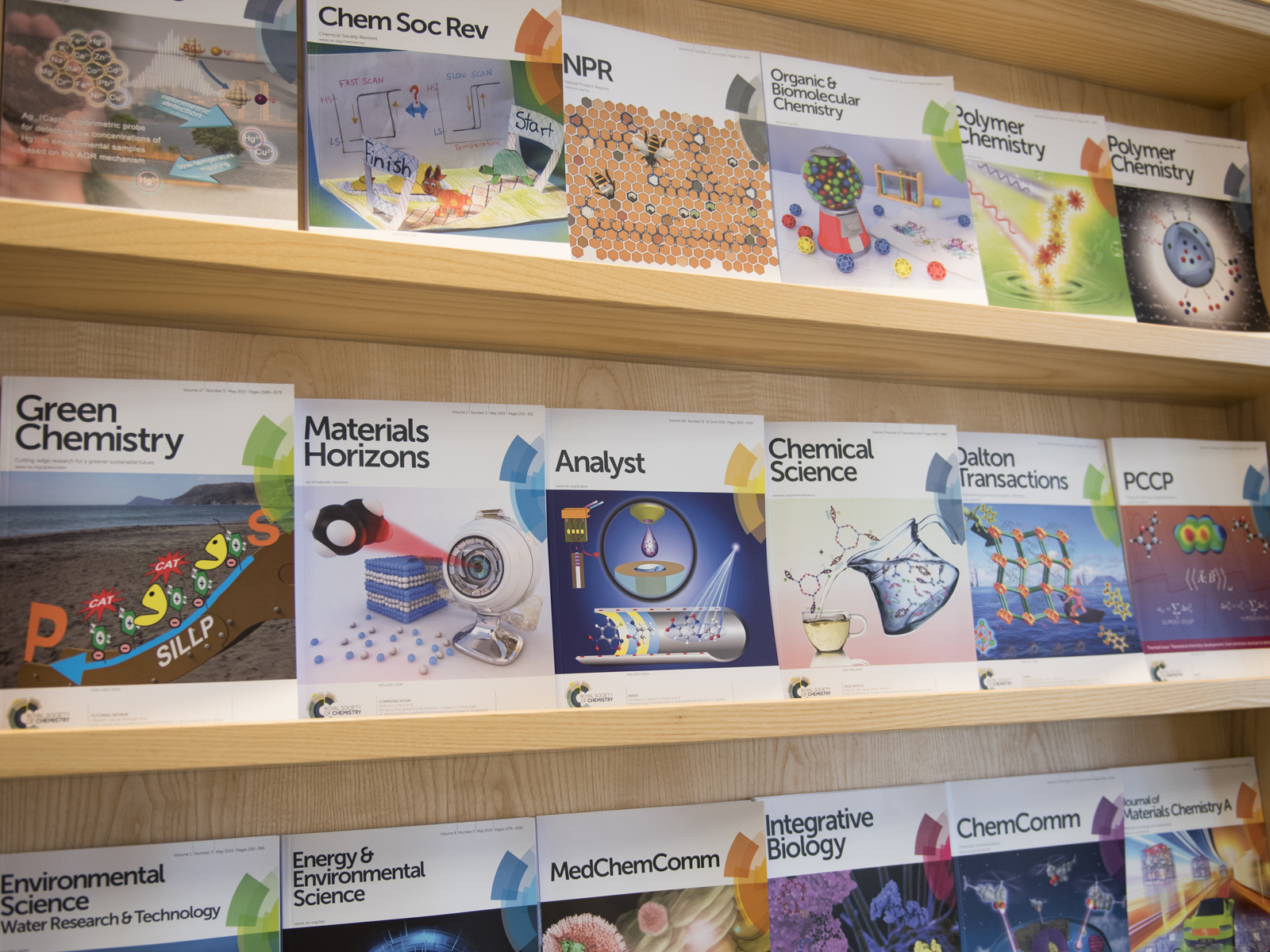 The front covers of several RSC journals on modern wooden shelves The front covers of several RSC journals on modern wooden shelves