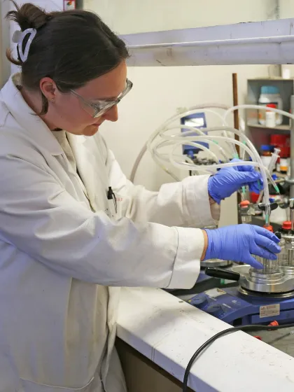 Member of Biocatalytic Nitro Hydrogenations team in lab wearing lab coat and gloves