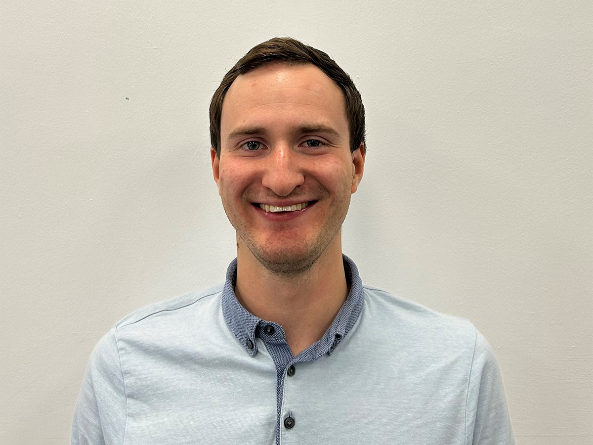 Dr Nathan Davison in pale blue shirt smiling at the camera