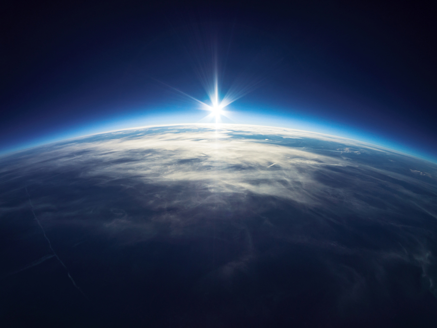 Earth from space with the sun shining on it 