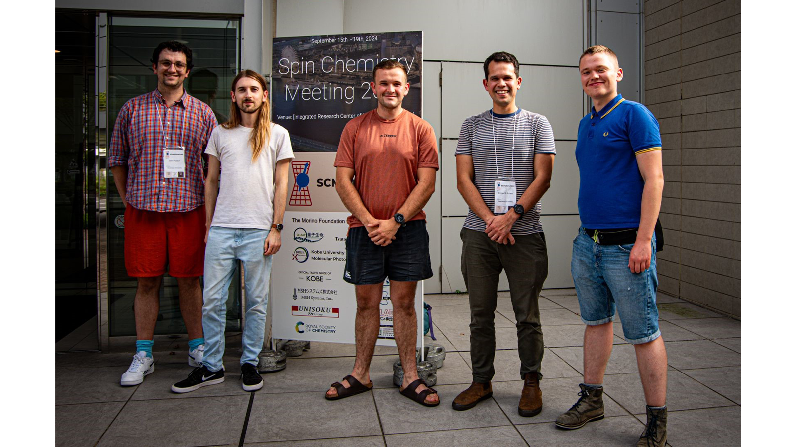 Dr Emrys Evans and team standing in front signage