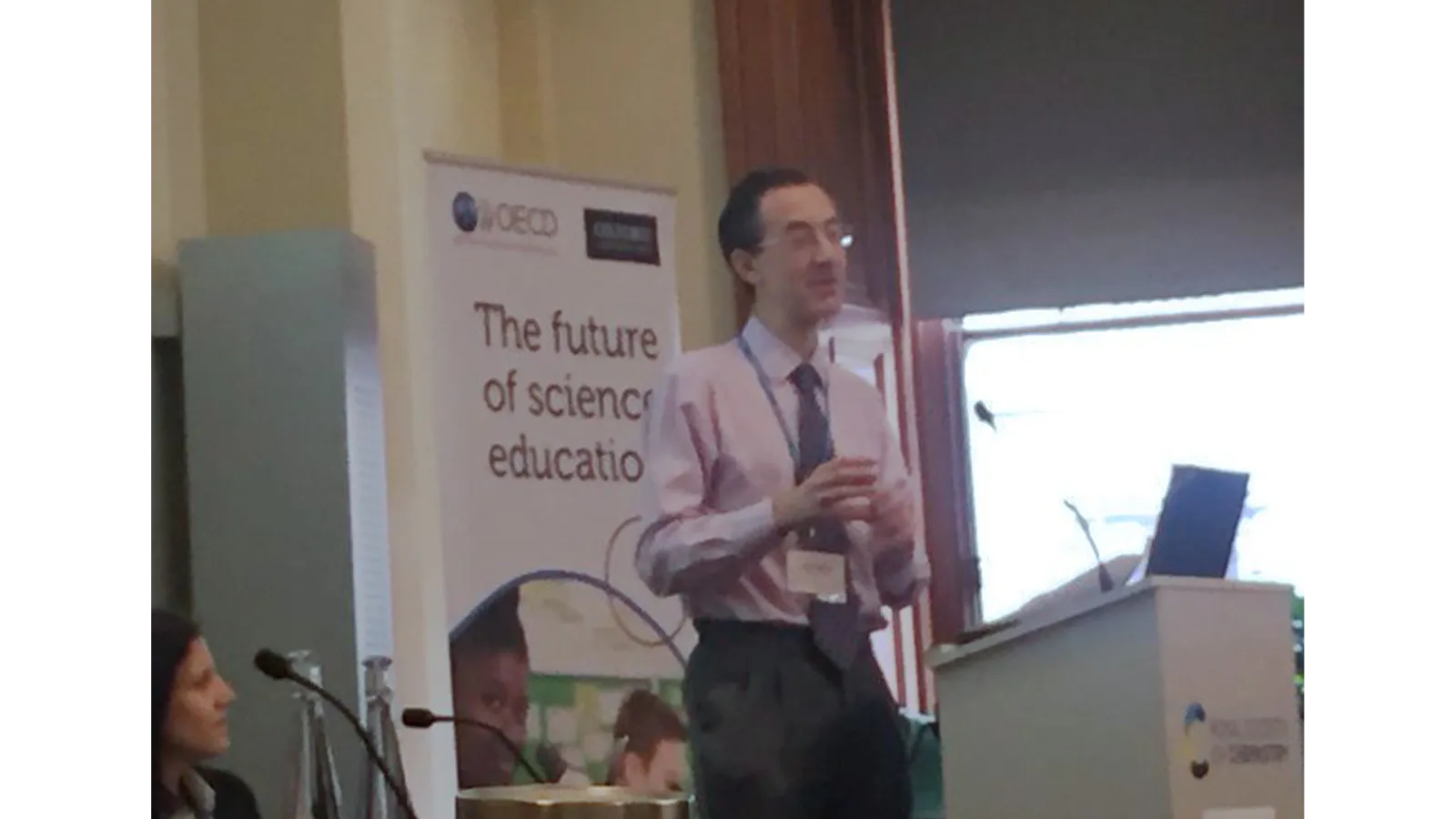 Dr James Redman presenting, standing at a podium