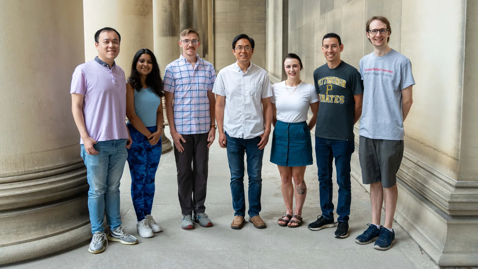 Nonheme iron-oxo oxidants team members outside a building with large pillars posing for photo