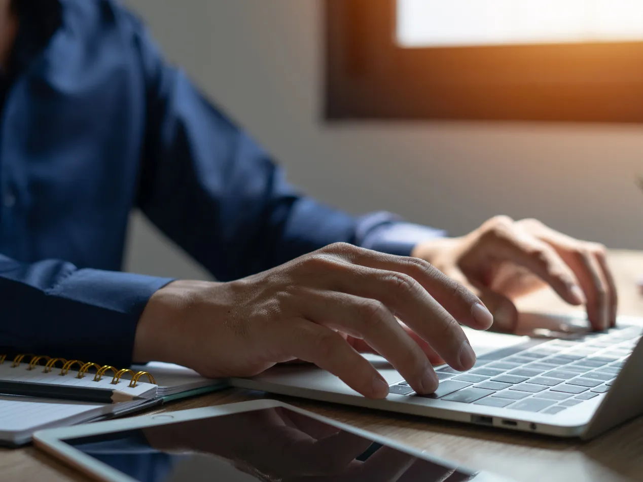 Close up of man working on laptop computer on office table