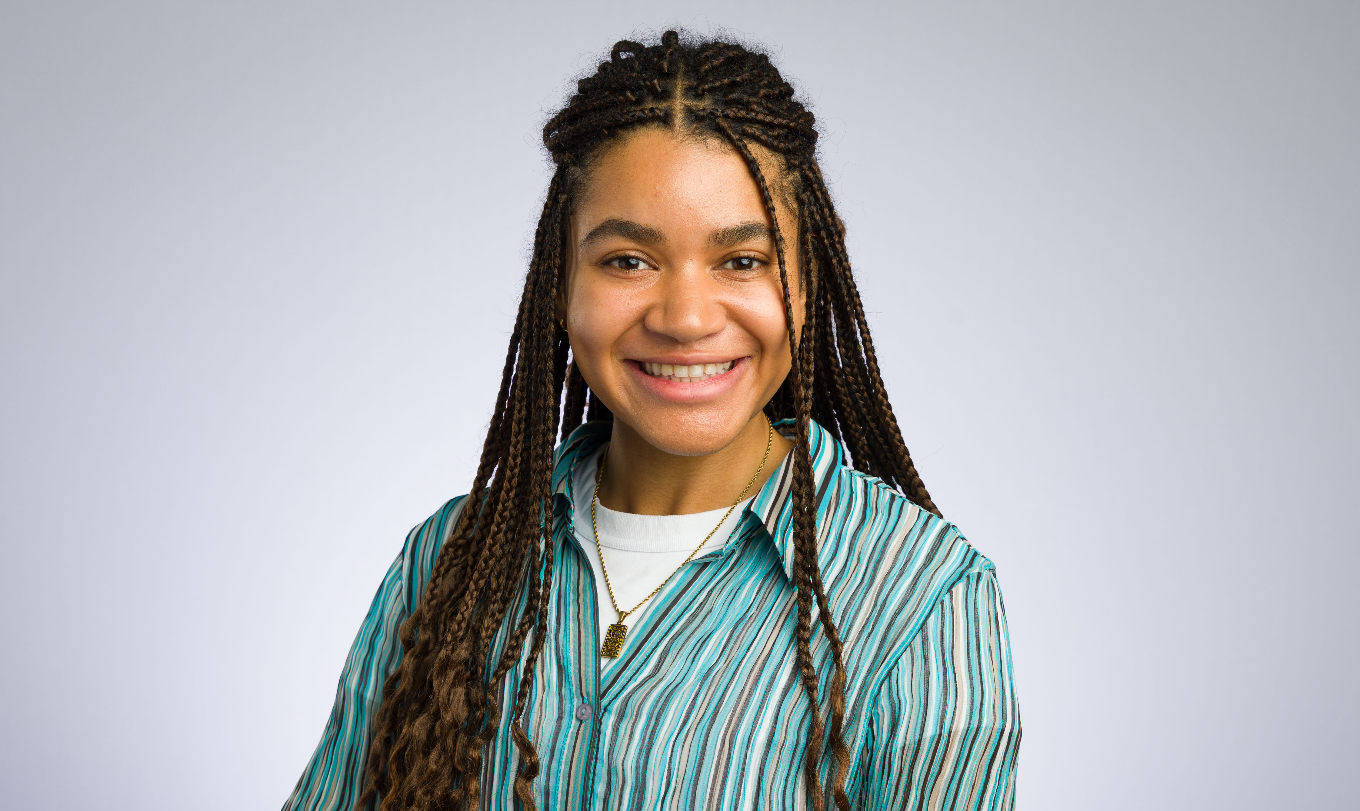 Christina Dumitriu Jackson with braided hair and green striped shirt, smiling for the camera