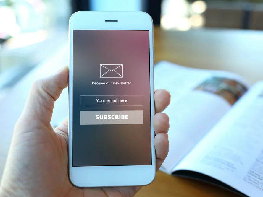 a person holding a phone showing an email notification