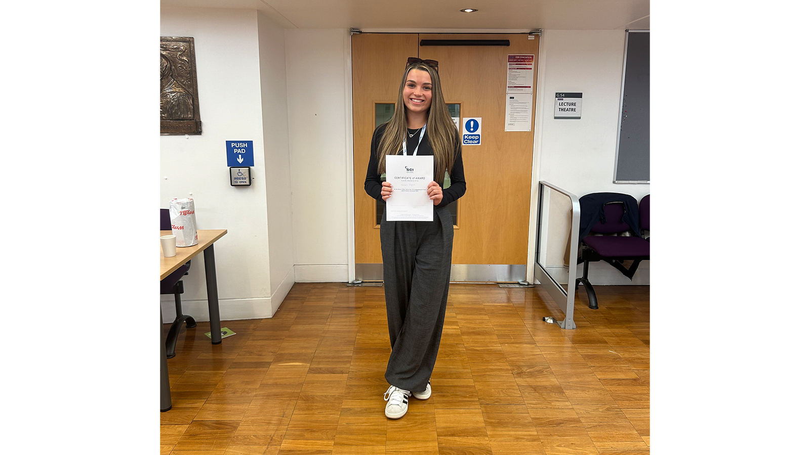 Georgia Wignall standing holding a certificate