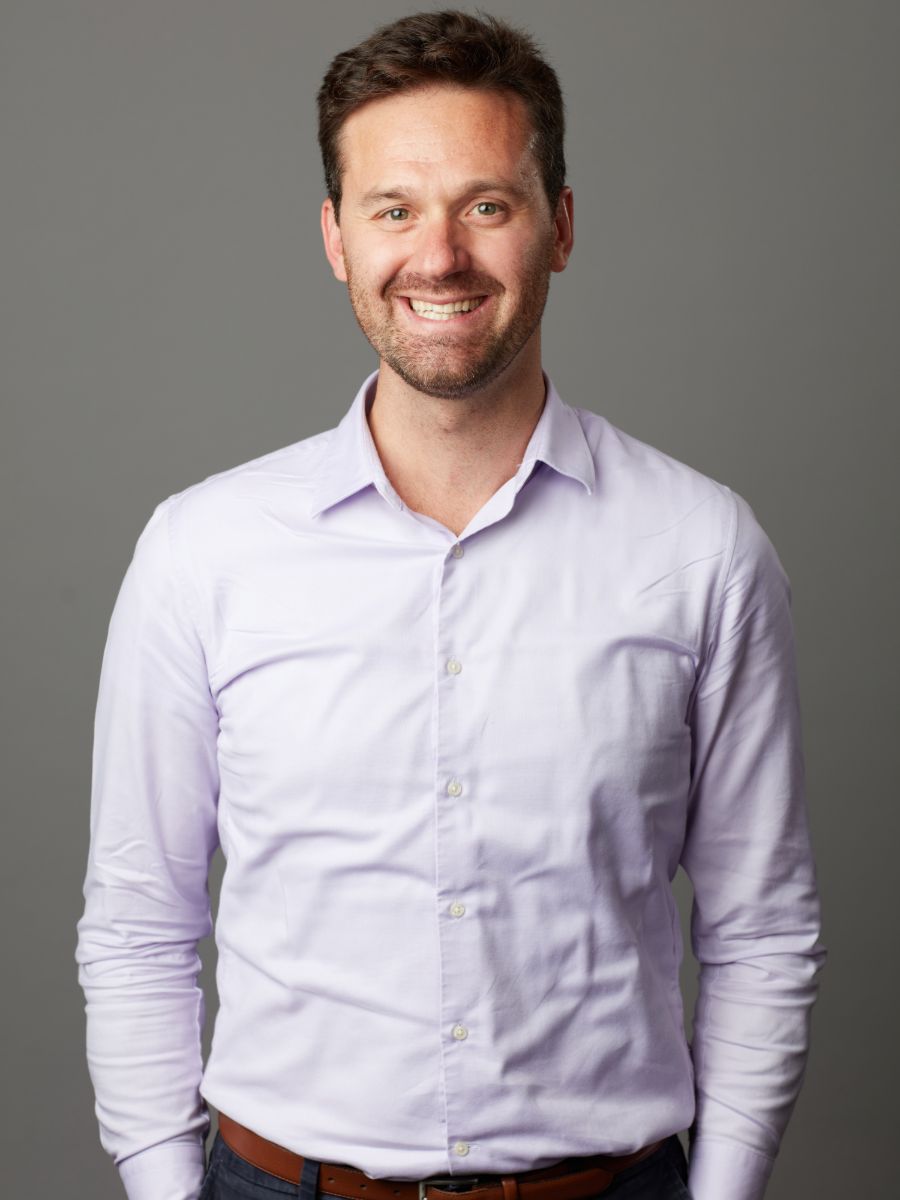 Professor Mauro Pasta in a white shirt smiling for camera